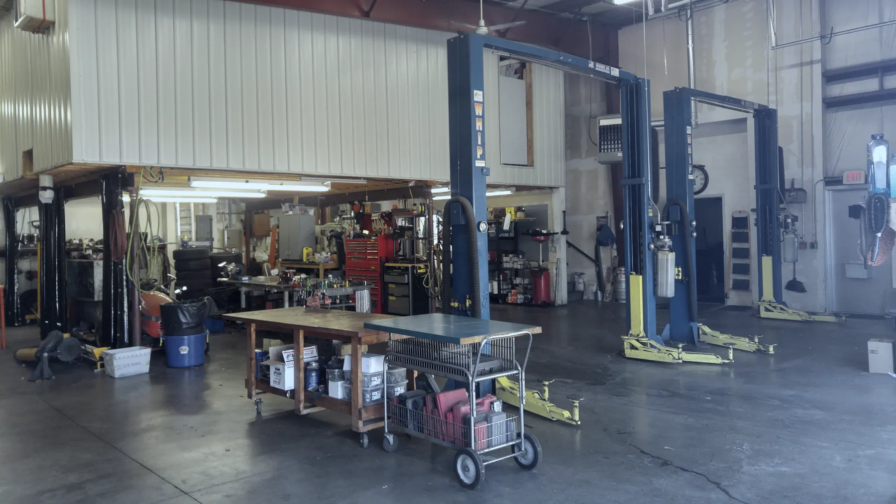 Blue vehicle lifts, worktables and tool carts inside the shop
