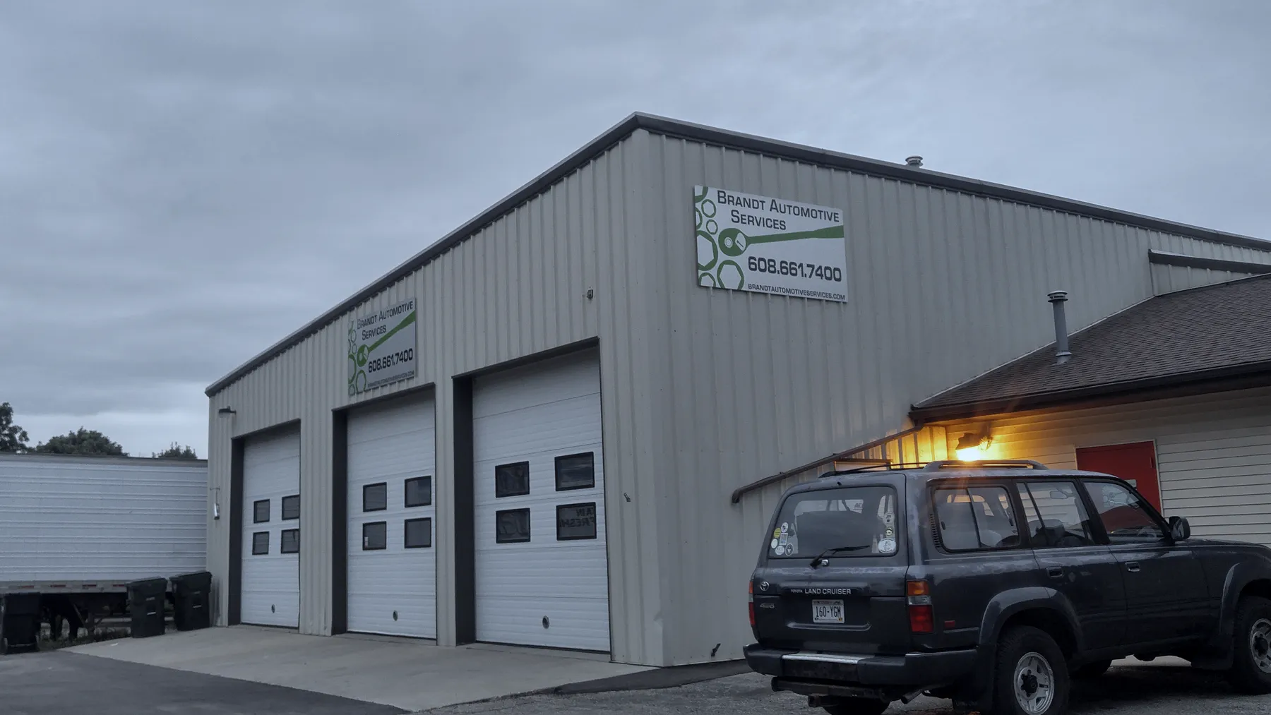 Brandt Automotive Services signs above the garage doors, with a dark SUV parked outside